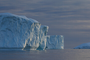 Fototapeta na wymiar sun reflections in big icebergs floating over sea