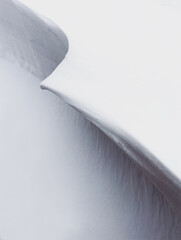 Close up of the clean snowy lines of a snow drift on a winter day.