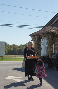 Girl with grandma in parking lot at a pumpkin patch