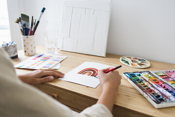 Person Painting with Watercolor on Desk With Art Materials