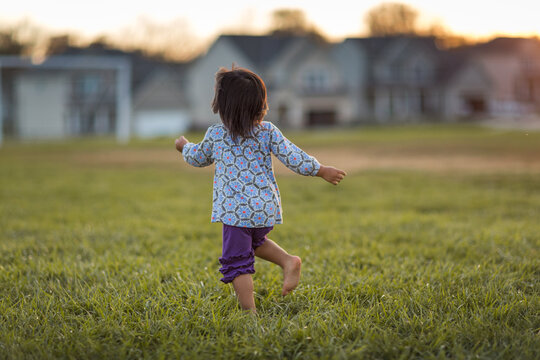 Young girl twirling dancing in a field