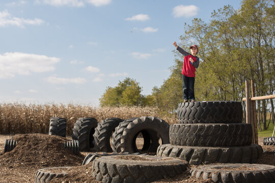 Kid posing at the top of a tire pile