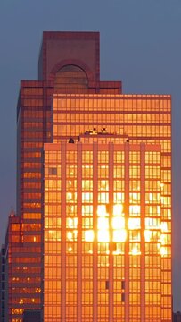 Golden sundown reflecting over Manhattan skyscraper facade, evening in New York City, time lapse, vertical video, social media wallpaper, 