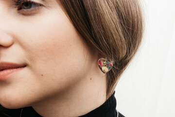woman wearing floral epoxy earrings   