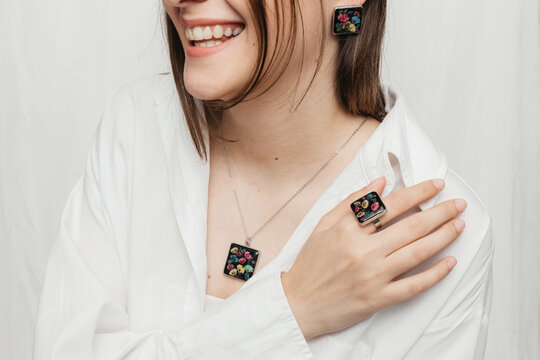 woman wearing floral epoxy necklace, earrings and ring