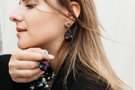 woman wearing floral epoxy earrings   