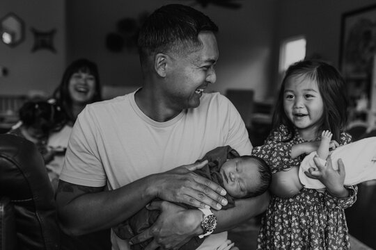 Smiling father and daughter with baby brother