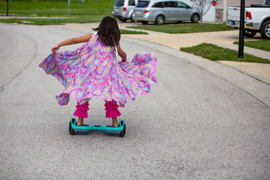 Girl in long flowing dress riding on a hoverboard