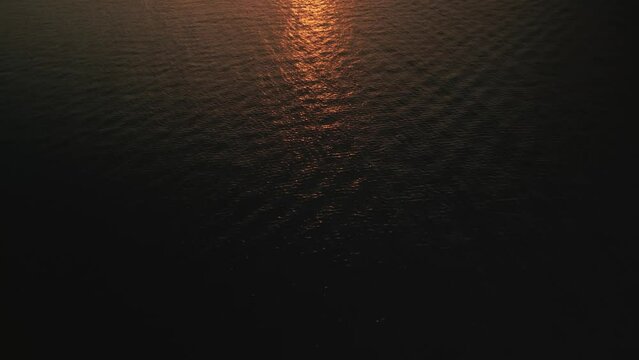 Tropical golden sunset over ocean water aerial view