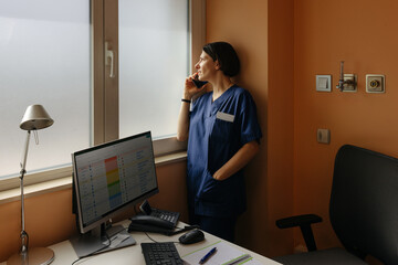 Woman doctor talking on cellphone while working in a hospital
