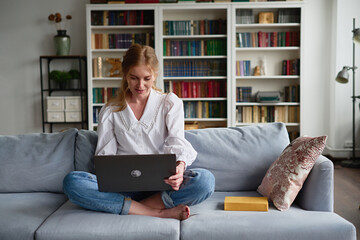 Woman With Laptop Sitting On The Sofa At Home

