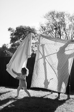 Little girl playing under the clothes line