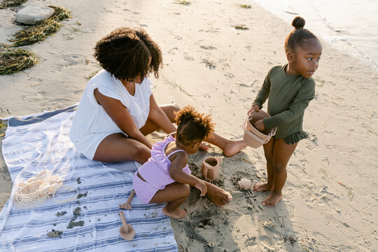 A mom playing with her kids in the sand