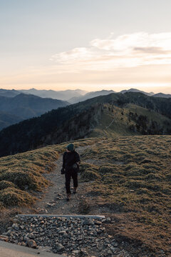 Unrecognizable traveler walking on path in mountains
