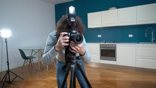 Photographer man taking pictures and video in apartment - real estate home photoshoot for selling house whit professional estate agency - home staging and enhance the property for advertising - 
