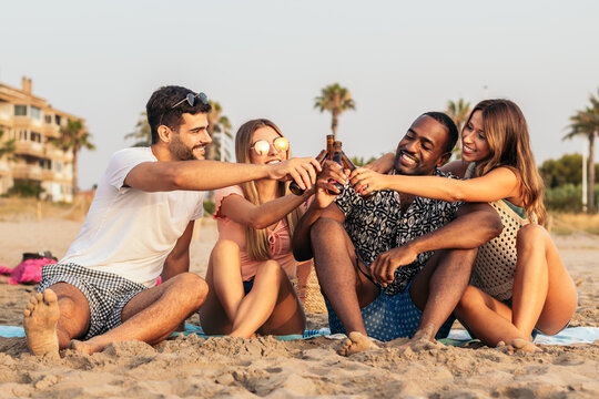 Young adult friends drinking beer on the beach