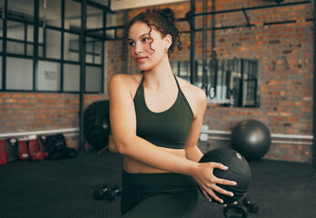 Fitness, medicine ball and exercise of a woman at gym doing weight training for body wellness,...