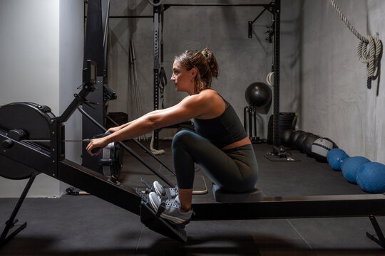 Sportswoman exercising on rowing machine