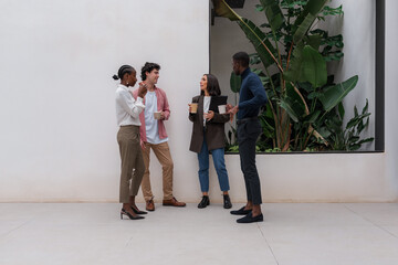 Diverse colleagues having coffee break near window