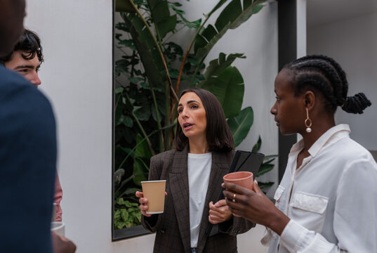 Businesswoman speaking to coworkers during break