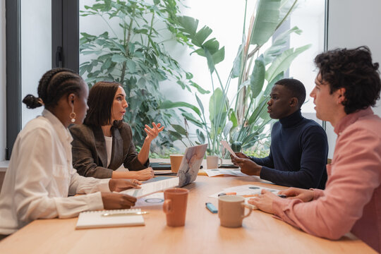 Diverse businesspeople negotiating against window