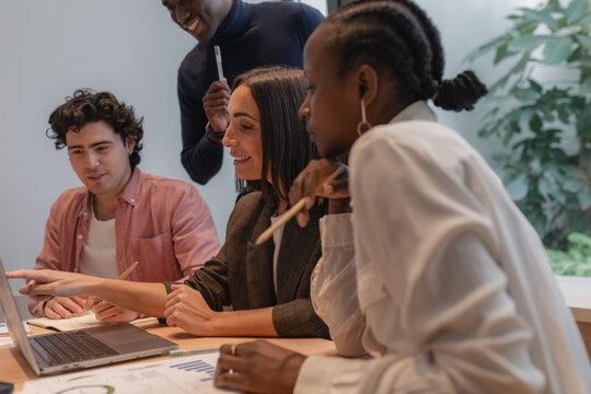 Glad businesswoman discussing data with colleagues