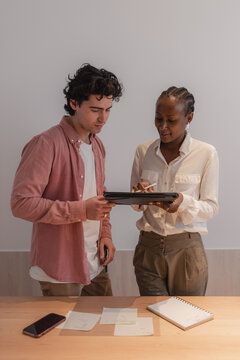 Multiracial businesspeople discussing data near table