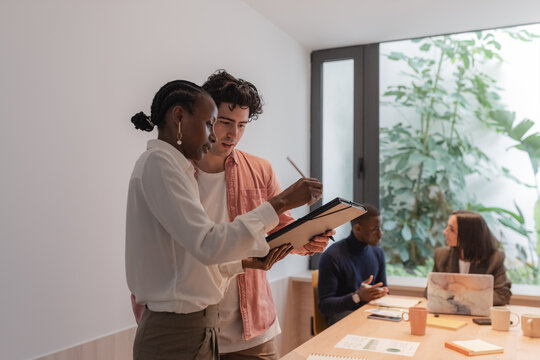 Diverse colleagues discussing papers from folder