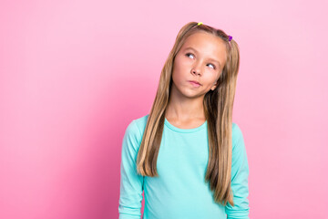 Closeup photo of youngster preteen cute little lady long blonde hair dreamy pouted lips interested look empty space isolated on pink color background