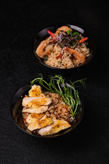 Two bowls of rice on black background