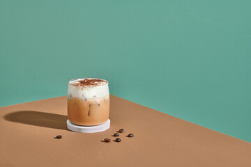 Cappuccino in a double walled glass with roasted coffee beans