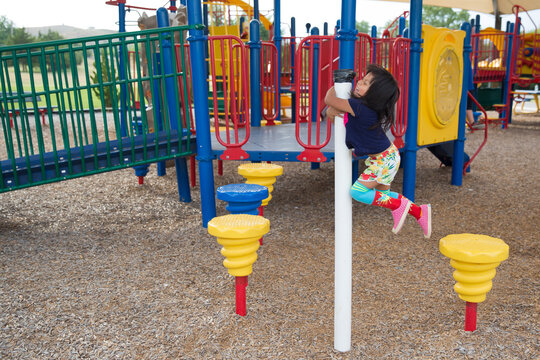 Girl in colorful knee socks climbing in park