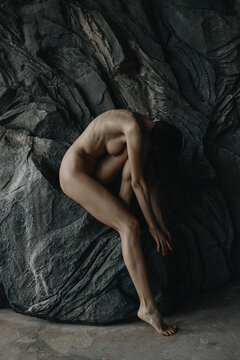 Anonymous Naked skinny woman sitting on a rock 