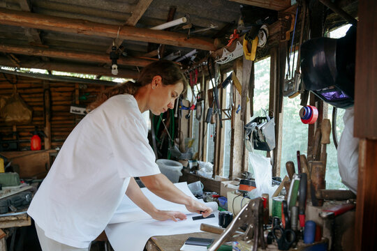 A female farmer works in a workshop in the countryside