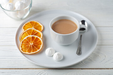 Coffee with cream, fluffy protein cake and dried oranges
