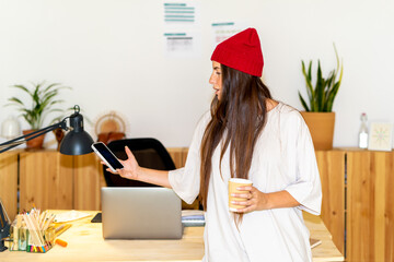 woman checking phone at cozy office 