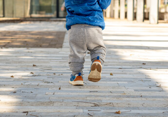Baby's first steps. Running toddler outdoors. Walking little boy