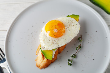 Avocado toast with melted cheese and scrambled eggs