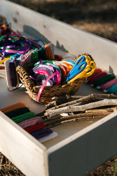 Wooden sensory box with colorful ribbons and yarns
