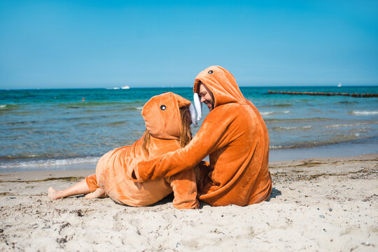 Walruses dressed couple laying on the beach