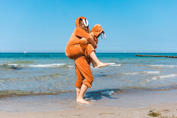 Walruses couple piggyback ride along the beach