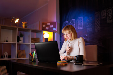 Woman having online meeting writing in planner