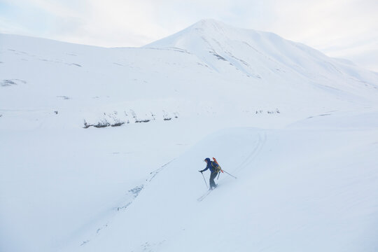 A backcountry skier makes turns down Foxdalen, Svalbard.