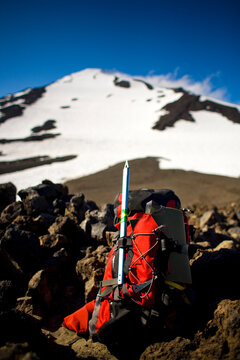 A backpack sits on rocks with the summit of Mount Adams in the distance in Washington.