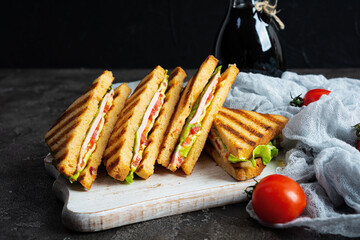 Club sandwich with ham, tomato, green and cheese. Grilled panini