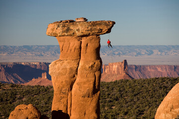 man rappelling off of rock spire, Moab, Utah