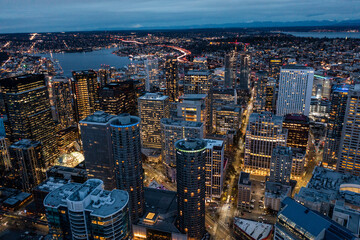 Seattle, Washington, USA - Jan.2023, night aerial view of illuminated Seattle Downtown with skyscrapers, traffic on streets and Lake Union in background - aerial night view