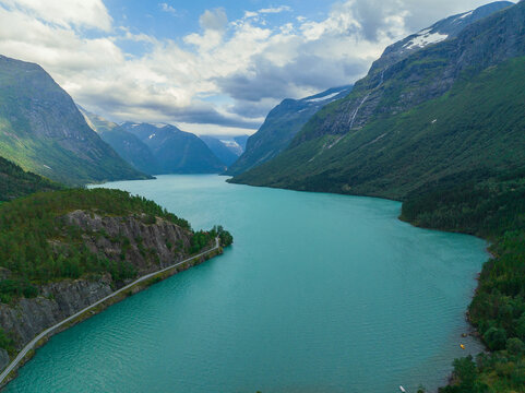 Aerial view of turquoise lake surrounded by forest in Norway 