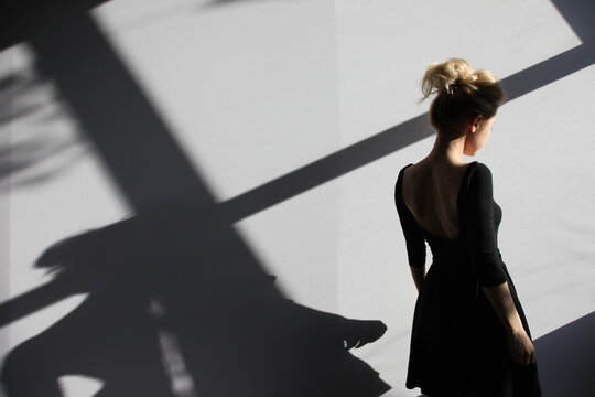 Anonymous woman in sun shadow in studio