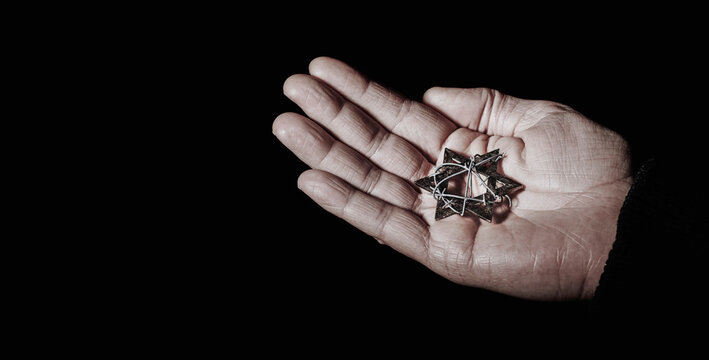 star of david with barbed wire in the hand of a man